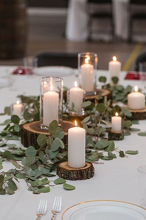 Centro de mesa rústico con hojas verdes y velas