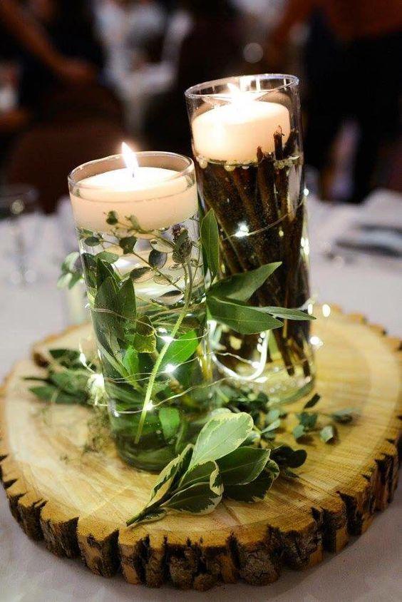 centro de mesa rústico con hojas verdes y velas